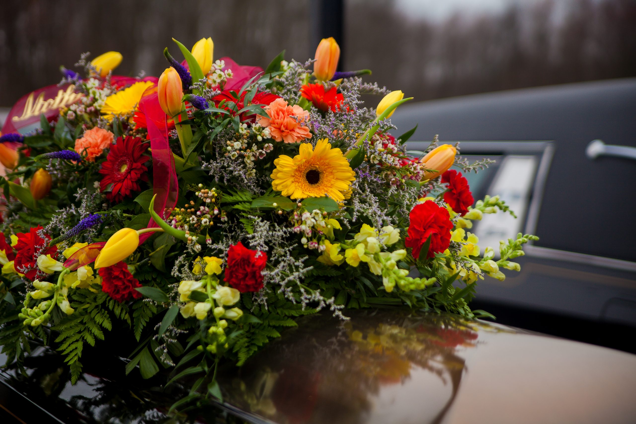 funeral-casket-and-flowers-next-to-hearse-2021-08-31-18-11-54-utc