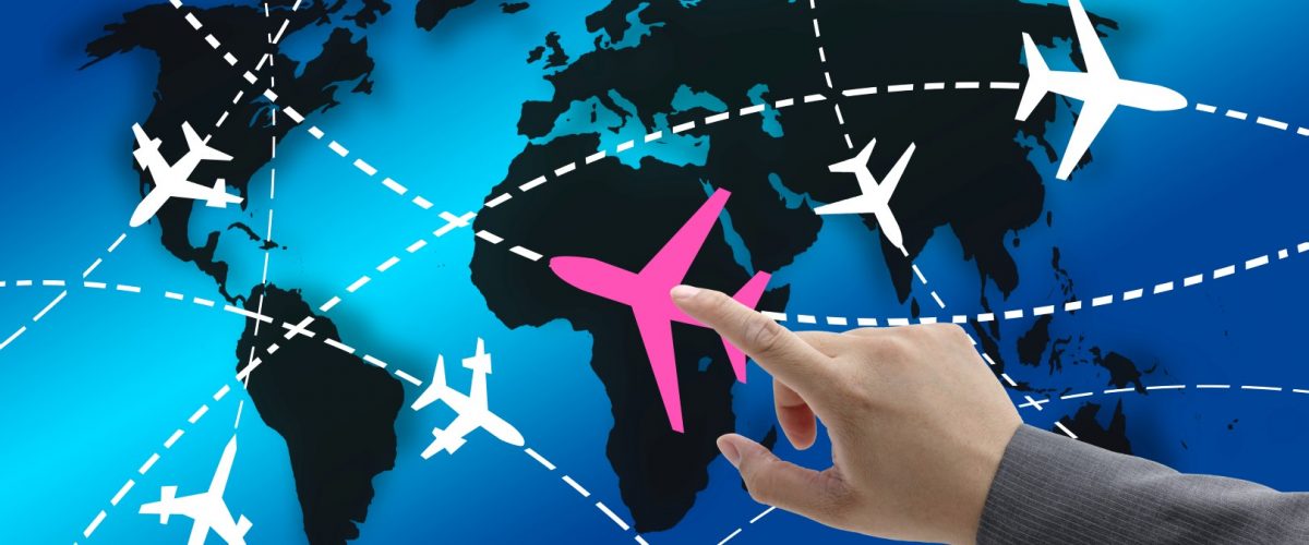 hand touch on planes with routes around the world for business travel concept